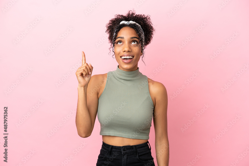 Young latin woman isolated on pink background pointing up and surprised Young latin woman isolated on pink background pointing up and surprised