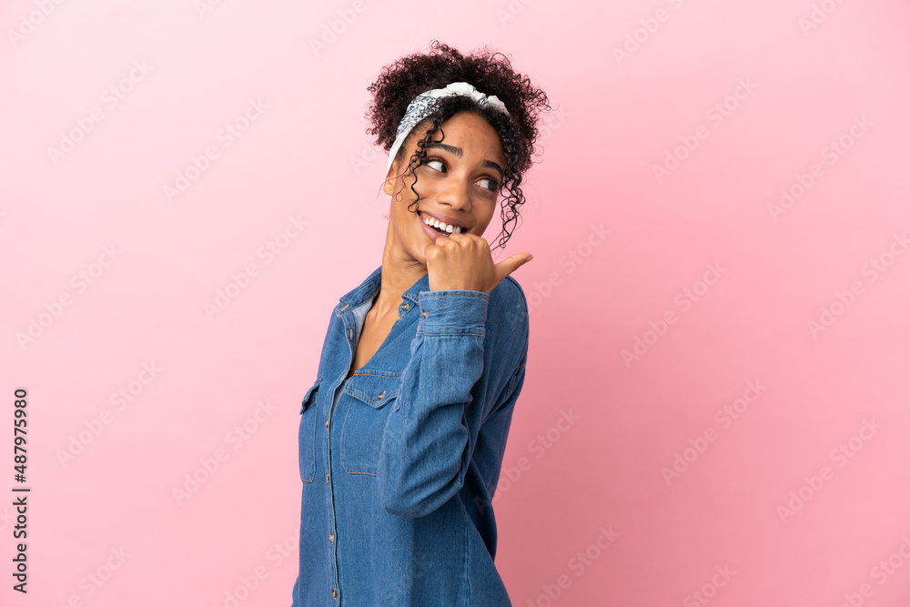 Young latin woman isolated on pink background pointing to the side to present a product Young latin woman isolated on pink background pointing to the side to present a product