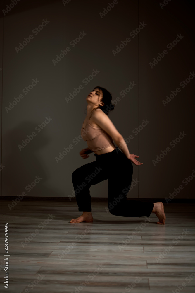 Slender flexible dance performer during a dance practice in modern studio Slender flexible dance performer during a dance practice in modern studio