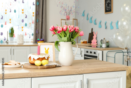 Photography Easter cake, candle, eggs, cookies, picture and vase with tulips on counter in k
