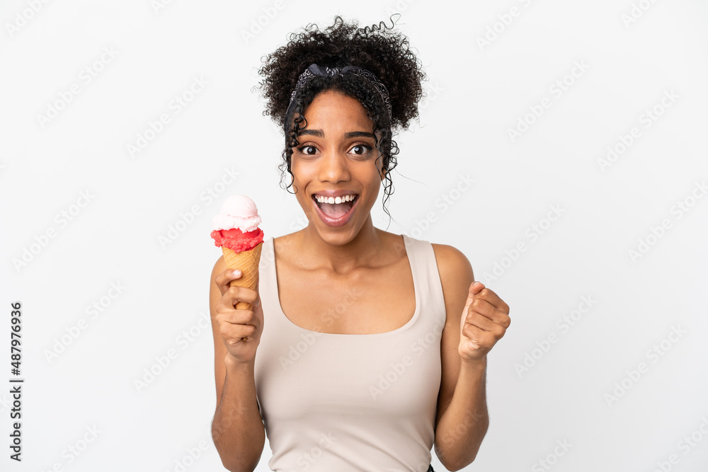 Young african american woman with a cornet ice cream isolated on white background celebrating a victory in winner position Young african american woman with a cornet ice cream isolated on white background celebrating a victory in winner position