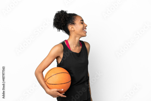 Young basketball player latin woman isolated on white background laughing in lateral position © luismolinero