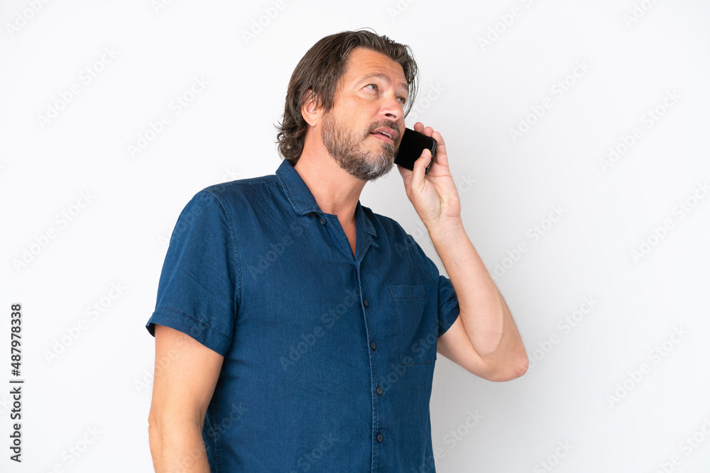 Senior dutch man isolated on white background keeping a conversation with the mobile phone Senior dutch man isolated on white background keeping a conversation with the mobile phone