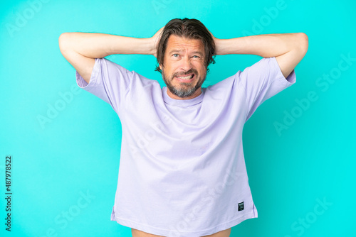 Senior dutch man isolated on blue background doing nervous gesture