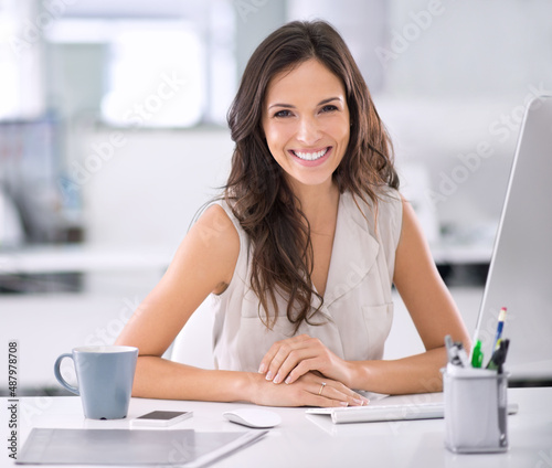 Shes made it. Shot of an attractive businesswoman sitting at her desk in an office.