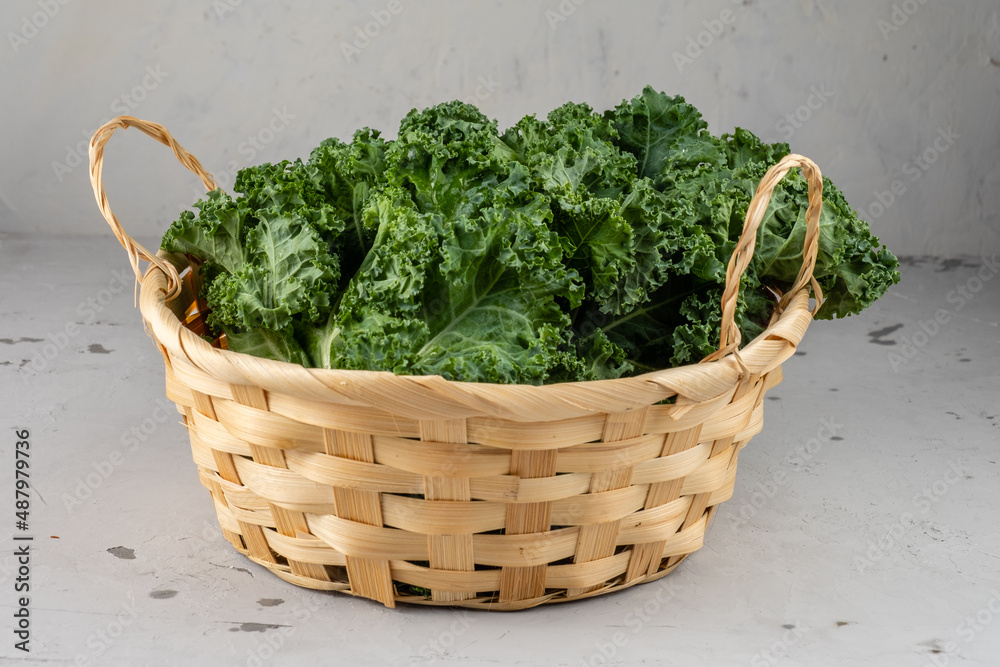 Fresh cabbage kale in a basket on a gray background. Fresh cabbage kale in a basket on a gray background.