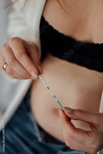 Young woman holds with both hands a positive pregnancy test © Анастасия Гурза