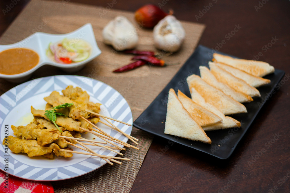 Pork satay - Grilled pork served with peanut sauce or sweet,sour sauce and toast, Thai street food and delicious food in the restaurant. Pork satay - Grilled pork served with peanut sauce or sweet,sour sauce and toast, Thai street food and delicious food in the restaurant.