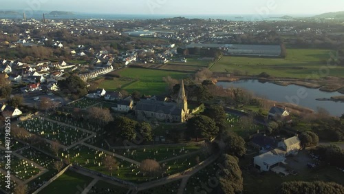 Aeriel reveal of Vale Church  churchyard and bird watching pool L’Abbaye Vale Guernsey with views to the east coast and Herm and Jethou in the distance photo