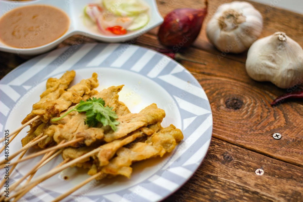 Pork satay - Grilled pork served with peanut sauce or sweet,sour sauce and toast, Thai street food and delicious food in the restaurant. Pork satay - Grilled pork served with peanut sauce or sweet,sour sauce and toast, Thai street food and delicious food in the restaurant.