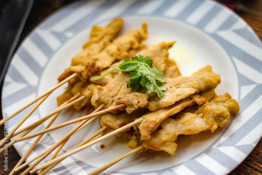 Pork satay - Grilled pork served with peanut sauce or sweet,sour sauce and toast, Thai street food and delicious food in the restaurant. Pork satay - Grilled pork served with peanut sauce or sweet,sour sauce and toast, Thai street food and delicious food in the restaurant.