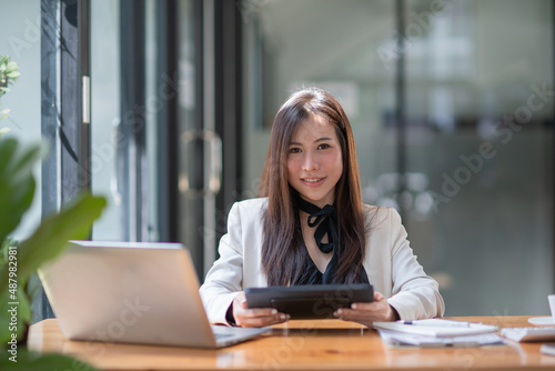 Asian businesswoman with digital tablet, smiling to camera
