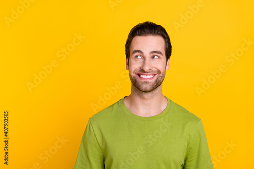 Photo of young cheerful man curious look empty space think clever isolated over yellow color background
