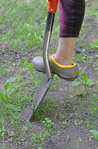 Leg of person digging  ground using  shovel