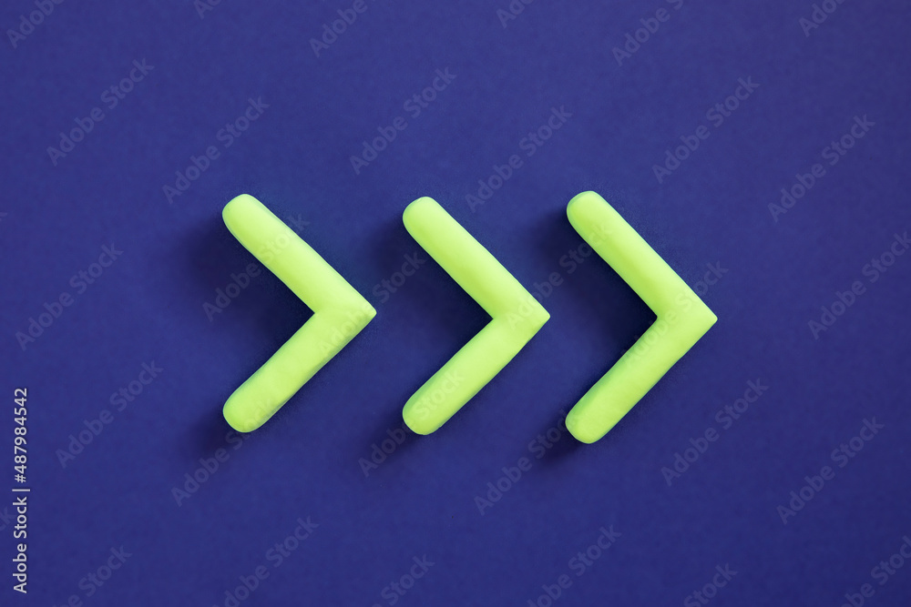 Green arrows pointing right side. Three dimensional arrow sign showing direction on blue background. Development concept, go green or heading target metaphor, striving for the goal, going forward.