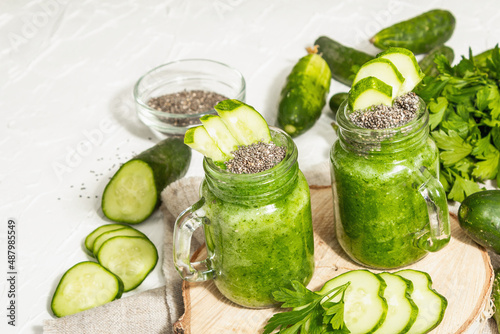 Green smoothie with cucumber in a glass jar. Fresh ripe vegetables, greens, and chia seeds