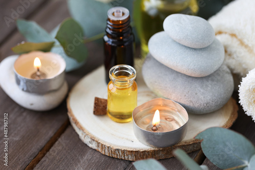 Assortment of natural oils in glass bottles on wooden background. Concept of pure organic ingredients in cosmetology. Bath accessoiries, atmosphere of harmony, relax. Close up macro. Healthy lifestyle