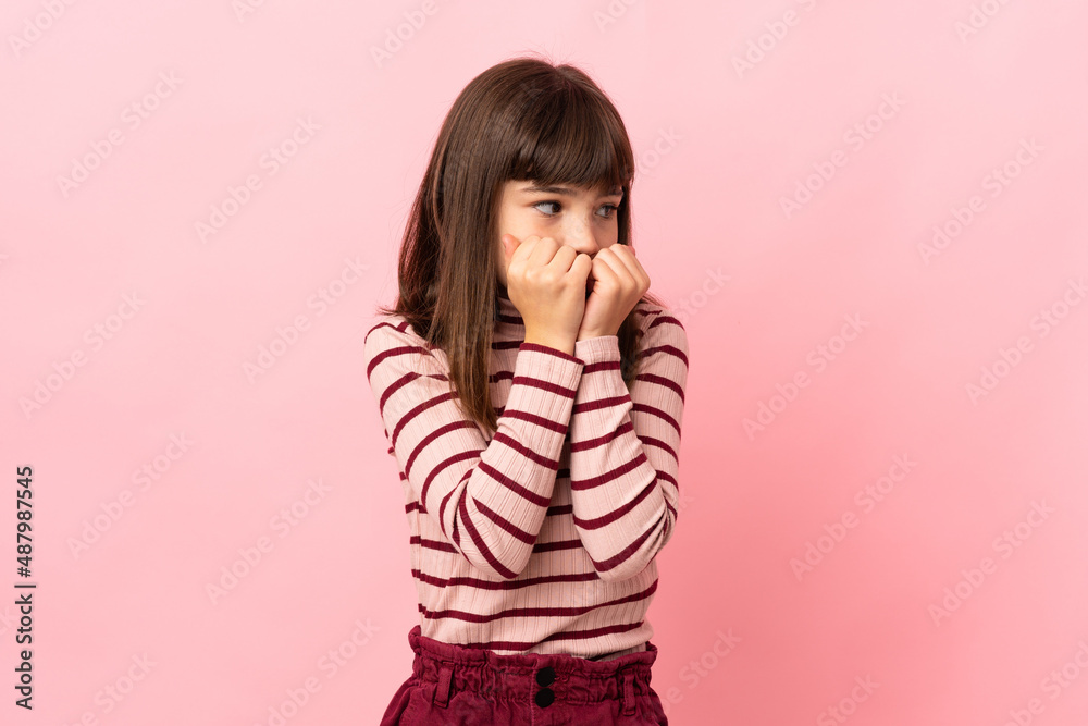 Little girl isolated on pink background nervous and scared putting hands to mouth Little girl isolated on pink background nervous and scared putting hands to mouth