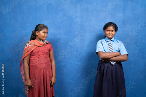 sad kid looking her self in smiling school dress or unifrom - concept of child dreaming about education, deprived schooling and poverty.