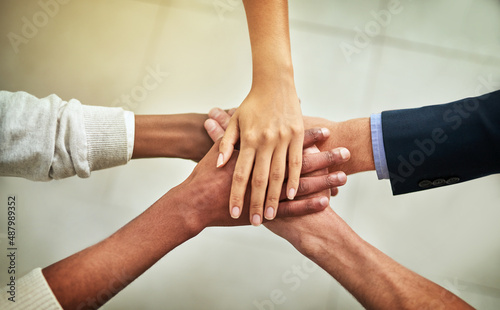 United in their business mission. Cropped shot of a group of businesspeople joining their hands in solidarity.