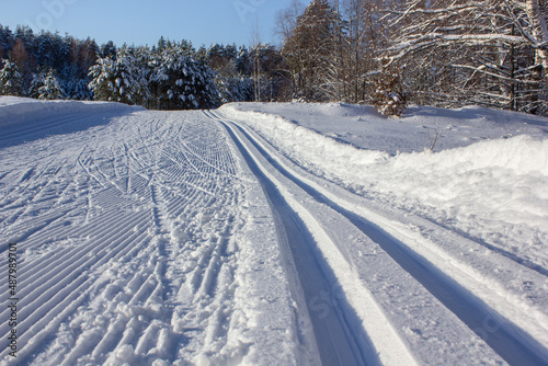 diagonal wide ski track with traces from many skis skating in winter forest