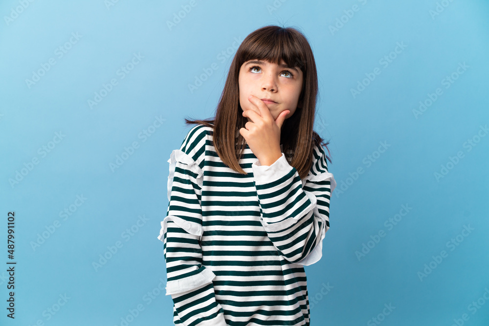 Little girl over isolated background having doubts and with confuse face expression Little girl over isolated background having doubts and with confuse face expression