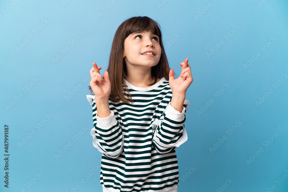Little girl over isolated background with fingers crossing and wishing the best Little girl over isolated background with fingers crossing and wishing the best