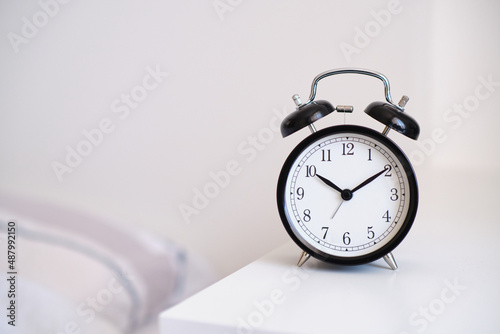 Black alarm clock on night stand, ten past ten oclock