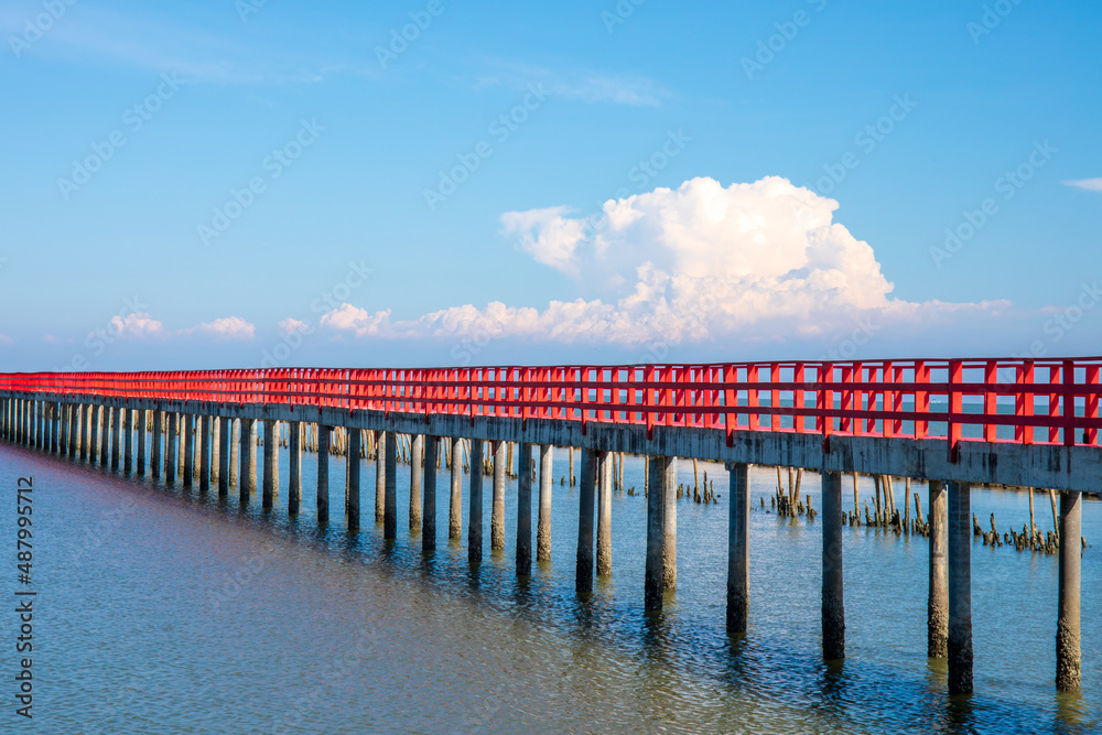 Beautiful landscape photo of red long wooden bridge with blue sky in Samut Sakhon province, Thailand. Asia.