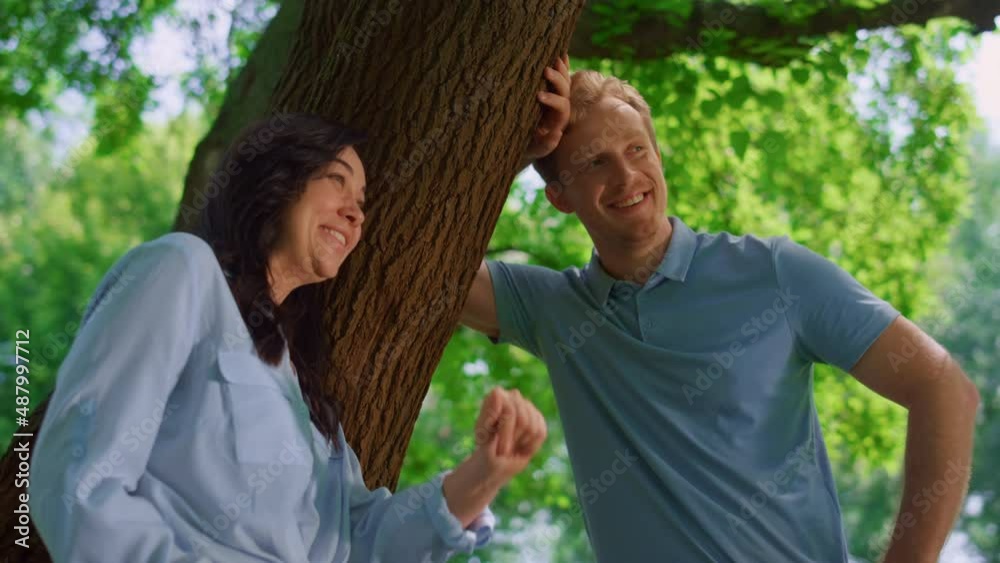 Lovely couple talking lean on tree close up. Pretty wife laughing with husband. Lovely couple talking lean on tree close up. Pretty wife laughing with husband.