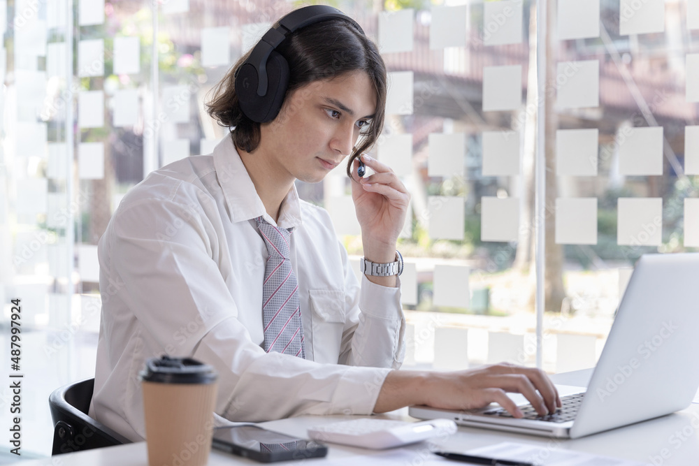 Businessman are greeting friends and manager through video chats and use headphones for communication and business conversations, Online communication, New normal, VDO Call, Internet learning. Businessman are greeting friends and manager through video chats and use headphones for communication and business conversations, Online communication, New normal, VDO Call, Internet learning.