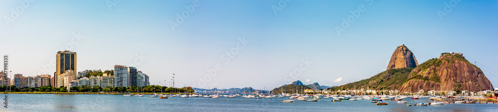 Panoramic image of Rio de Janeiro with the boats moored, the Sugarloaf hill, Guanabara bay and Botofogo beach surrounded by the buildings and mountains of the city