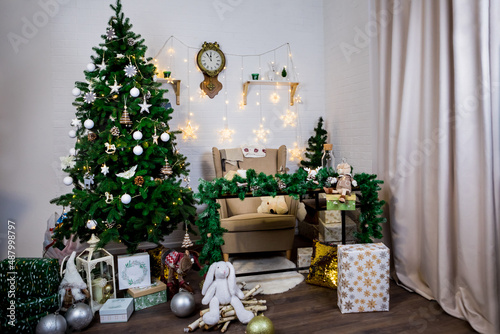 Christmas and New Year photo studio, green tree, soft chair, garlands stars, clock on a white wall (9). Idea for holiday like Christmas and New year, for covers books, magazines, articles.  © Gennadii