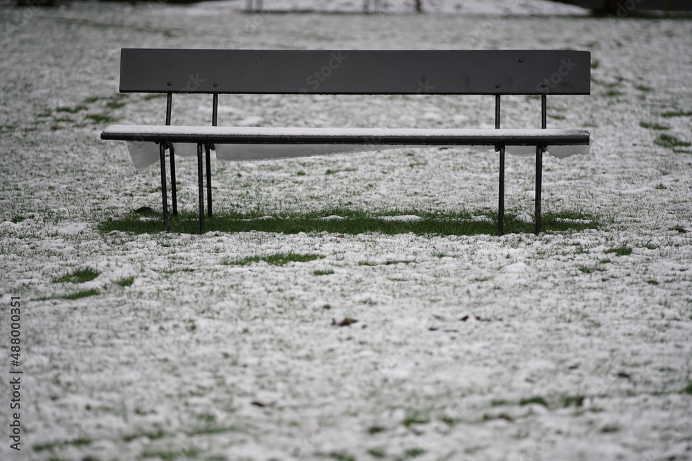 Parkbank in einem Park zur winterlichen Jahreszeit und mit leichtem Schnee bedeckt Parkbank in einem Park zur winterlichen Jahreszeit und mit leichtem Schnee bedeckt