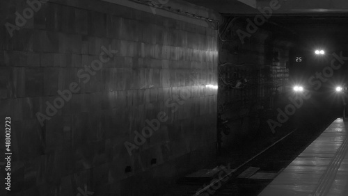 Black and white photo. Moving underground train. The arrival subway train at the station. City without traffic jams.