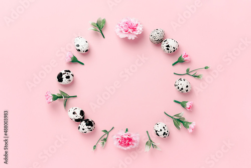 Easter round composition of spring herbs, eggs, and flowers on a pink pastel background. Minimal easter concept. Flat lay with copy space.