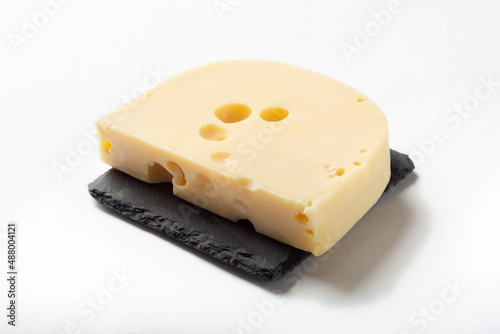 Maasdam cheese on a white background for insulation. Maazdam cheese on a stone board