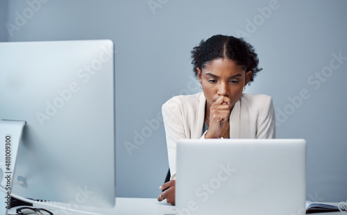 There are some things the undo button cant fix. Shot of a young businesswoman using a laptop and looking anxious at her desk in a modern office. photo