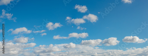 Panoramic view over blue deep sky with clouds as a background with copy space.
