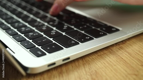 Close-up of woman hands typing on a laptop keyboard. Slow motion footage