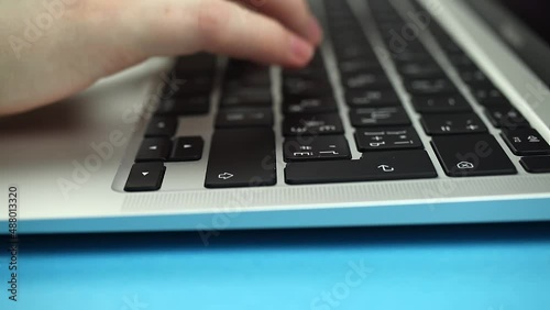 Close-up of woman hands typing on a laptop keyboard. Slow motion footage