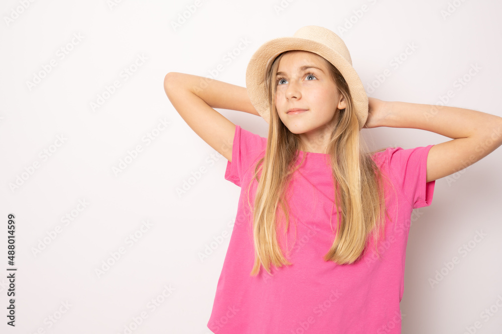 Beautiful relaxed little girl wearing straw hat standing isolated over white background. Holidays concept. Beautiful relaxed little girl wearing straw hat standing isolated over white background. Holidays concept.