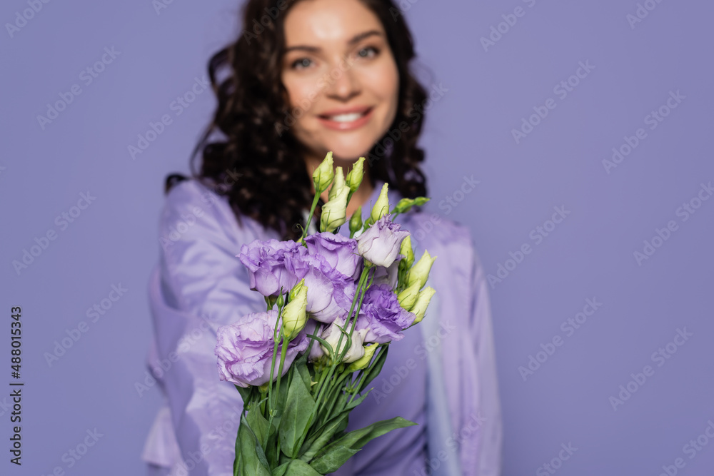 happy blurred woman holding bouquet of flowers isolated on purple. happy blurred woman holding bouquet of flowers isolated on purple.