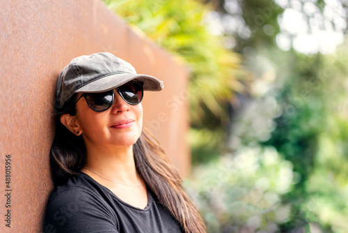 young latin woman smiling portrait with sunglasses and hat