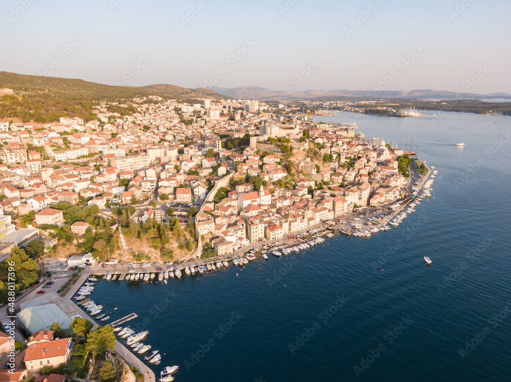 Aerial dronw view of sunset over the Sibenik city, Croatia. Ancient and old town coastline with harbor near the sea. Fortress above the city. Famous tourist destination in Croatia.