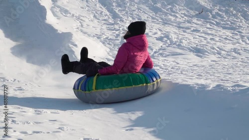 Fun Young woman with snow tubing winter activity, runs in winter. Winter entertainment. Slow motion
