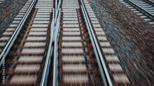 Fast Moving Railway Track with Switches Concrete Railroad Ties and Crushed Stone Track Ballast Seen from Train Driver Seat