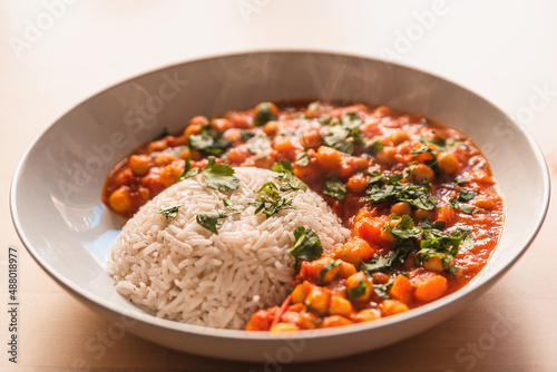 curry vegetarian chickpeas with vegetables. close up of fresh vegan indian curry, traditional meal of indian cuisine with coriander and basmati rice top view