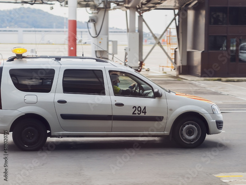 Russia, Sochi 02.11.2021. A white official car with a man in uniform at the wheel drives through the airfield. Airport Service