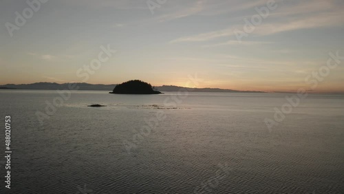Flying around a small rocky island during sunset in the pacific northwest of Washington state.